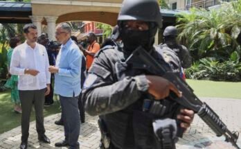 Le guardie di sicurezza guardano il Primo Ministro di Haiti, Alix Didier Son-Aime, al centro, parla con l'accusa del Messico, Jesus Cisneros, dopo aver partecipato a un evento significativo un anno dall'inizio della missione di sostegno alla sicurezza multinazionale a Port-Au-Prince, Haiti giovedì.