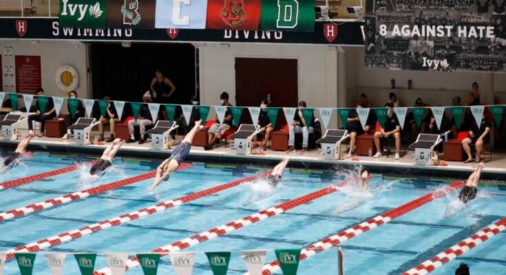 I nuotatori, tra cui Lia Thomas di Penn, Lane 4, si tuffano in acqua all'inizio di un calore di qualificazione senza 200 metri ai campionati di nuoto della Ivy League e femminile all'Università di Harvard, il 18 febbraio 2022 a Cambridge, Messa.